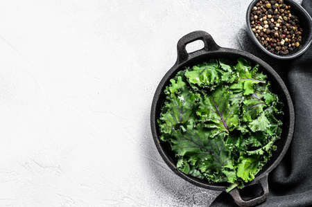 Raw Green Kale salad in a pan. Organic Vegetarian food. White background. Top view. Copy space.の写真素材