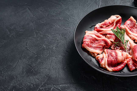 Strips of marbled beef, quick steak. Black background. Top view. Copy space.の写真素材