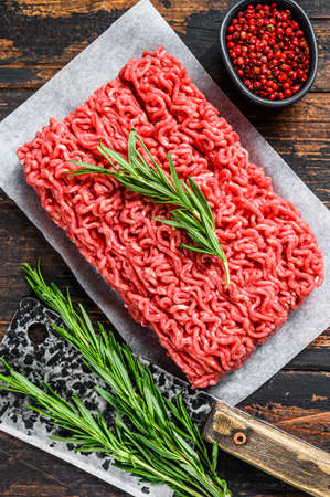Raw forcemeat beef, ground meat on butcher paper. Dark wooden background. Top view.の写真素材