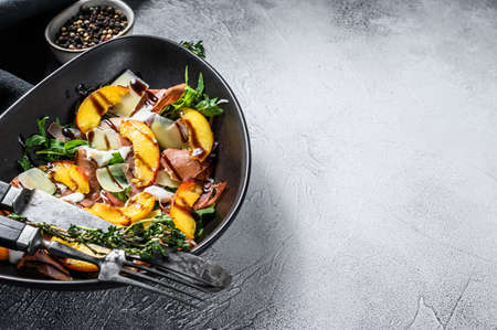 Salad with jamon Iberico, arugula, peach and Parmesan. Gray background. Top view. Copy space.の写真素材