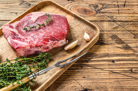 Raw beef Club steak on a cutting board. wooden background. Top view. Copy space.の写真素材