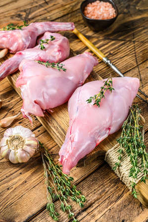 Raw rabbit legs on a cutting Board. Wooden background. Top view.の写真素材