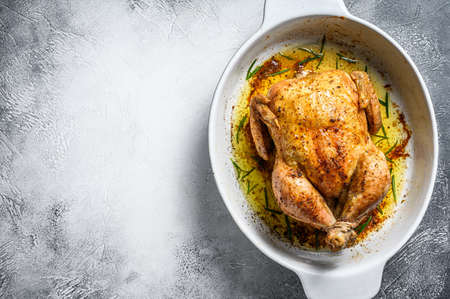 Delicious baked, crispy chicken served on a ceramic dish. White background. Top view. Copy space.
