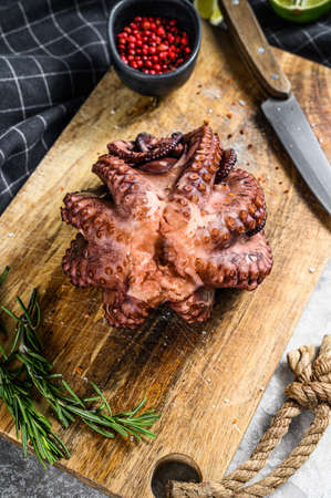 Cooked octopus on a cutting Board. Gray background. Top view.