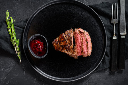 Sliced grilled marbled beef steak. Beef tenderloin. Black background. Top viewの写真素材
