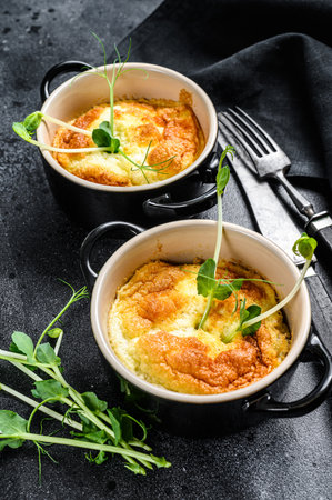 Cheese omelette, omelet with microgreens in a pan. Black background. Top view.の写真素材