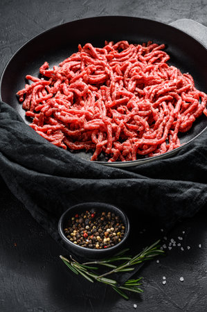 Mince. Ground meat with ingredients for cooking. Black background. Top view.の写真素材