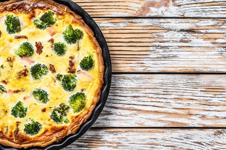 Quiche tart with smoked salmon, broccoli and spinach. White wooden background. Top view. Copy space.の写真素材