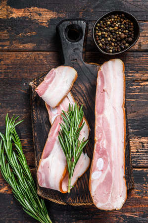 Raw pork belly with skin. Dark wooden background. Top view.