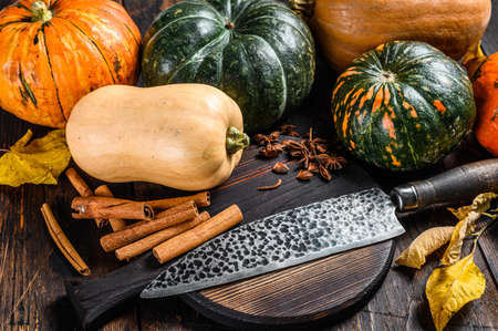 Food composition with pumpkins, knife and cutting board. Dark Wooden background. Top view.の写真素材