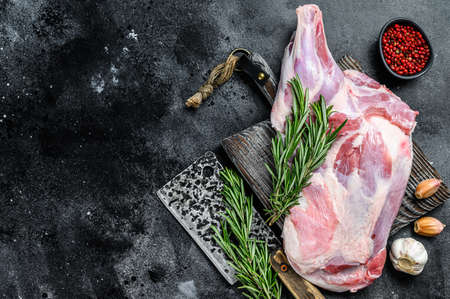 Raw lamb shoulder meat ready for baking with garlic, rosemary. Black background. Top view. Copy space.の写真素材