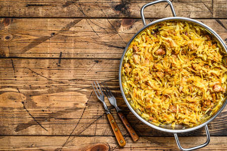 Bigos cabbage stewed with meat, mushrooms and sausages. Wooden background. Top view. Copy space.の写真素材