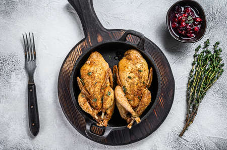 Whole roast quails in a pan. White background. Top view.の写真素材