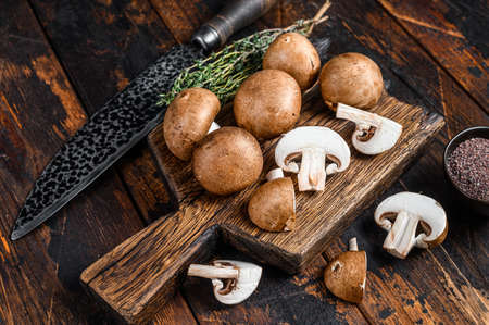 Cut Raw Royal brown champignon mushrooms. Dark wooden background. Top view.の写真素材