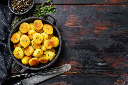 Homemade Potato Gnocchi fried in a pan. Black wooden background. Top view. Copy space.の写真素材