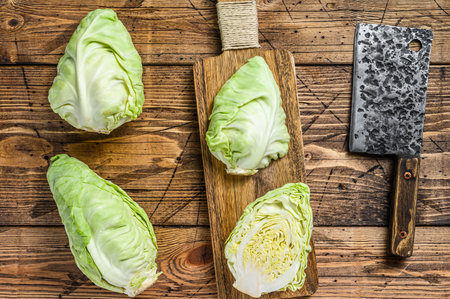 Fresh Green pointed cabbage. Wooden background. Top view.の写真素材