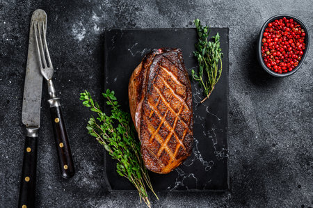 Roasted Christmas duck breast fillet steak. Black background. Top view.の写真素材