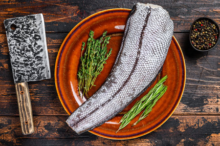 Fresh Raw grenadier macrurus white fish without head. Dark Wooden background. Top view.の写真素材