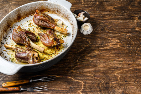 Homemade Braised Lamb Shanks in a baking dish. wooden background. Top view. Copy space.の写真素材