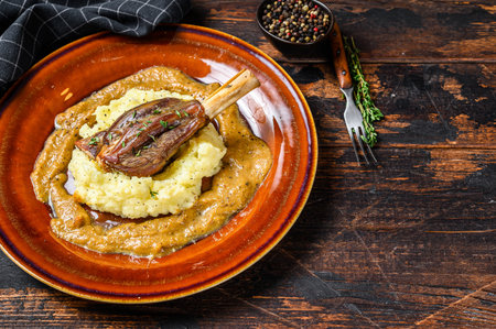 Stew Lamb Shanks with mash potato on a plate. Black background. Top view. Copy space.の写真素材