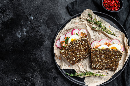 sandwich with hot smoked salmon and grain bread. trout. Black background, top view, space for text.の写真素材