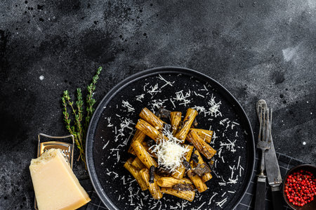 Pasta tortiglioni with black truffle, white mushroom, Cream Sauce and parmesan cheese. Black background. Top view. Space for text.の写真素材