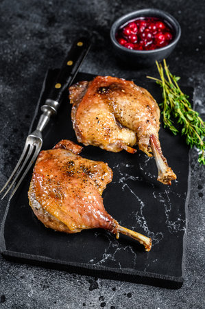 Roasted duck leg confit with cranberrie sauce. Black background. top view.の写真素材