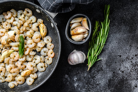 Roasted cooked Peeled Shrimps, Prawns in a pan. Black background. top view. copy space.の写真素材