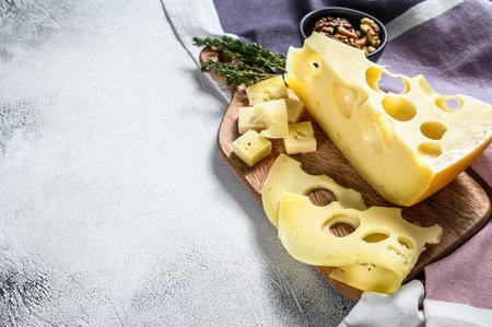 Maasdam cheese with holes, dairy yellow triangle. Gray background. Top view. Copy space.の写真素材