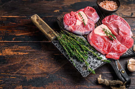 Raw veal shank steak meat osso buco, cooking italian ossobuco. Dark Wooden background. Top view. Copy space.の写真素材