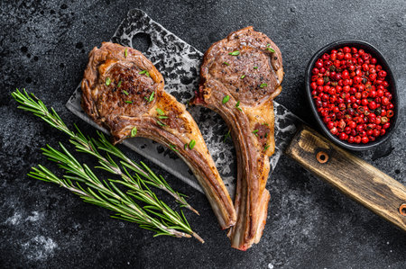 Barbecue grilled lamb chops on a butcher meat cleaver. Black background. Top view.の写真素材