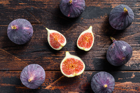 Purple figs on a wooden table. Dark wooden background. Top view.の写真素材
