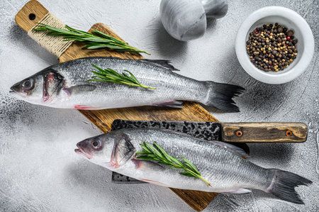 Raw Fresh fish seabass and ingredients for cooking. White background. Top view.の写真素材