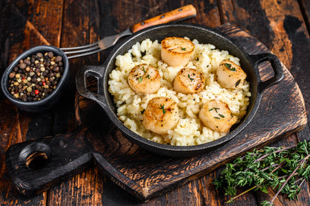 Seafood Risotto with Scallops in a pan. Dark wooden background. Top view.の写真素材