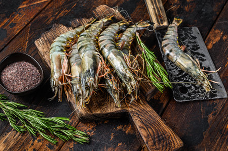 Fresh Raw black tiger prawns, shrimps on a cutting board. Dark wooden background. Top view.の写真素材