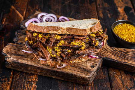 BBQ Texas Sandwich with slow roasted brisket beef meat. Dark wooden background. Top viewの写真素材