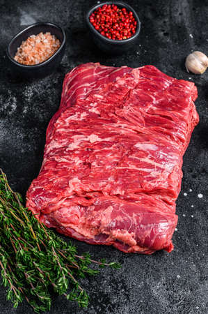 Raw fresh marble beef brisket meat with herbs. Black background. Top viewの写真素材