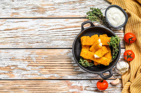 Oven baked crumbed fish sticks made from white fish. White background. Top view. Copy spaceの写真素材