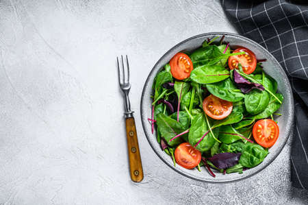 Healthy salad with mix leaves mangold, swiss chard, spinach and arugula in a salad bowl. White background. Top view. Copy spaceの写真素材