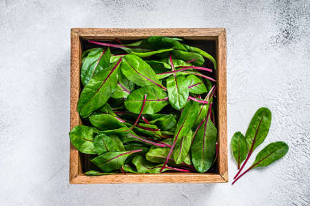 Raw Fresh green chard mangold leaves in a wooden box. White background. Top viewの写真素材