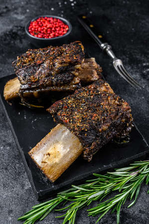 BBQ Beef Short Ribs with herbs. Black background. Top view