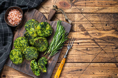 Roasted vegetarian broccoli and pea vegetable patty or cutlet, falafel. wooden background. Top view. Copy spaceの写真素材