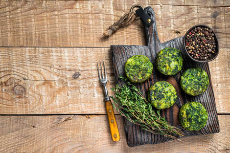 Vegetarian vegetable burgers patty with herbs on wooden board. Wooden background. Top view. Copy spaceの写真素材