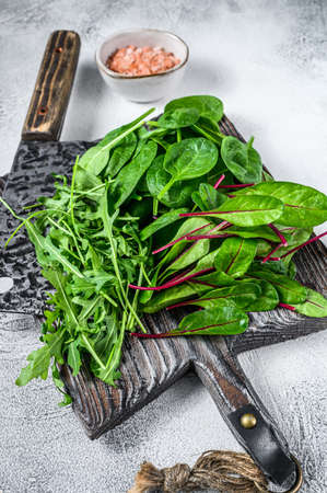 Fresh mixed greens, spinach, swiss chard and arugula. White background. Top view