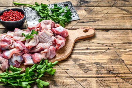 Raw uncooked chicken gizzards, stomach on a cutting board. wooden background. Top view. Copy spaceの写真素材