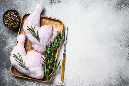Raw chicken legs on a cutting board. White background. Top view. Copy spaceの写真素材