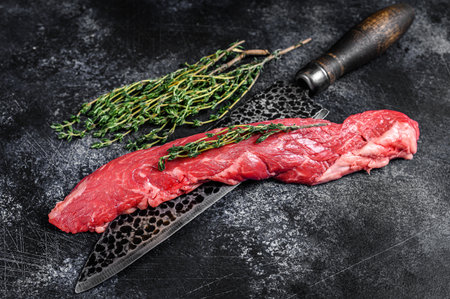 Raw skirt machete beef steak on a meat cleaver. Black background. Top viewの写真素材
