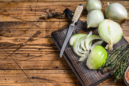 Sliced Raw white onion on a wooden cutting board. Wooden background. Top view. Copy spaceの写真素材