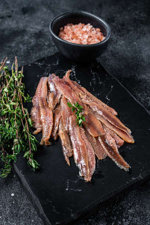 Anchovies fish fillet in Olive Oil. Black background. Top viewの写真素材