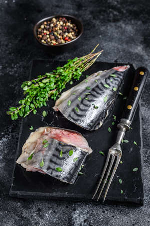Cold smoked mackerel fish with herbs. Black background. Top viewの写真素材